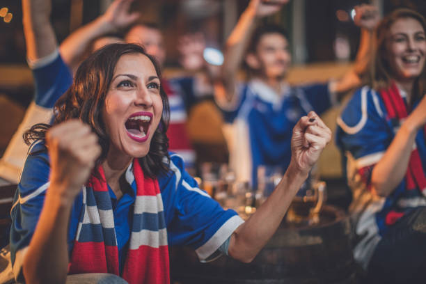 Group of friends watching game in a pub, focus on a woman shouting